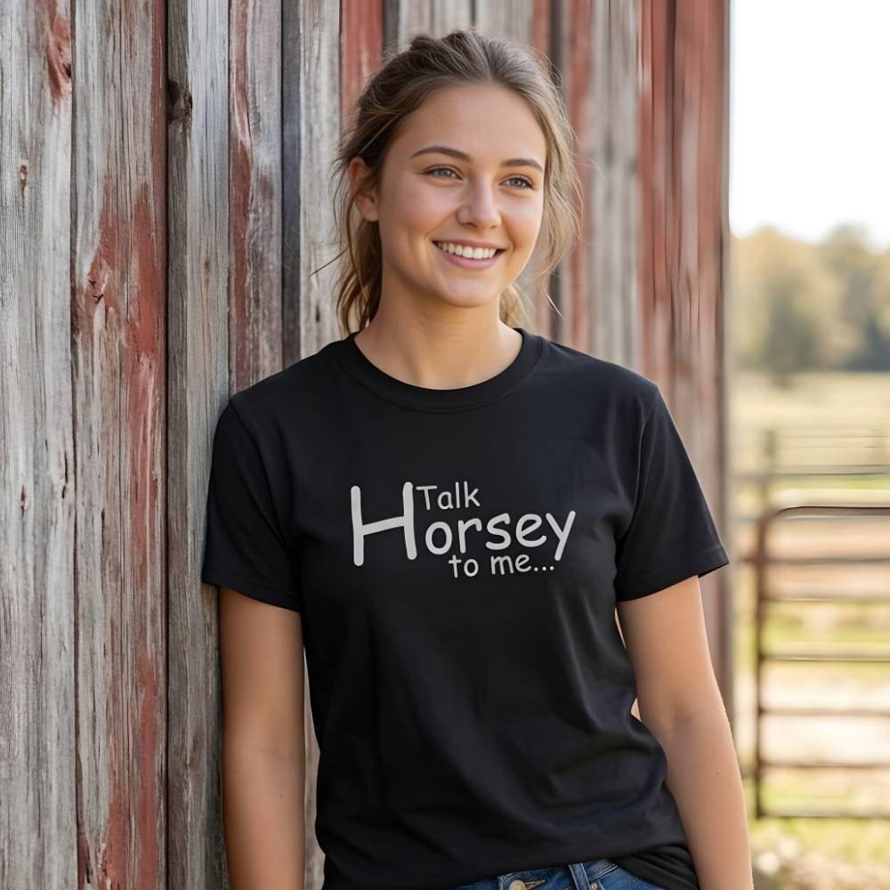 Woman wearing a black t-shirt with 'Talk Horsey to me...' text, standing against a wooden barn. Talk Horsey to Me T-Shirt for Horse Lovers, Trail Riding Tee Equestrian Barn Wear, perfect present for horse riders, mothers day gift, fathers day gift, xmas gift