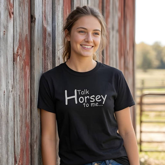 Woman wearing a black t-shirt with 'Talk Horsey to me...' text, standing against a wooden barn. Talk Horsey to Me T-Shirt for Horse Lovers, Trail Riding Tee Equestrian Barn Wear, perfect present for horse riders, mothers day gift, fathers day gift, xmas gift