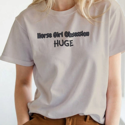 White t-shirt with 'Horse Girl Obsession HUGE' text worn by a person. Horse Girl Obsession T-Shirt for Horse Lovers, Trail Riding Tee, Equestrian Wear, perfect gift for horse riders, birthday present for horse lovers, mothers day gift for horse lovers, xmas gift for horse riders
