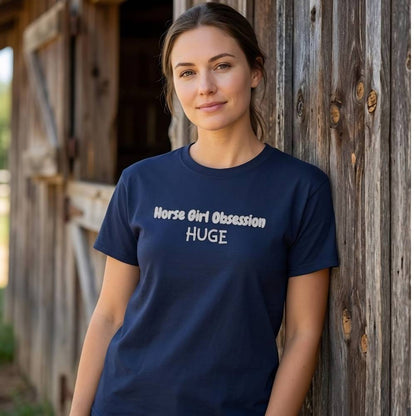Woman wearing a navy blue t-shirt with text, standing against a barn. Horse Girl Obsession T-Shirt for Horse Lovers, Trail Riding Tee, Equestrian Wear, perfect gift for horse riders, birthday present for horse lovers, mothers day gift for horse lovers, xmas gift for horse riders