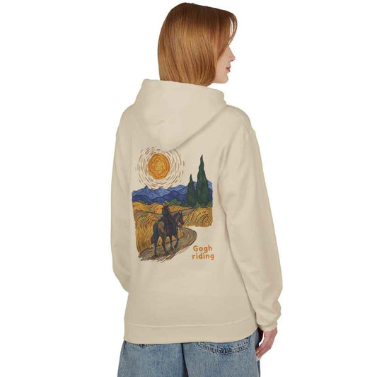 A woman shown from the back wearing a cream-colored hoodie with a large graphic print on the back. The print features a stylized Van Gogh-inspired scene of a rider on a horse at sunset, with the text 'Gogh Riding'.