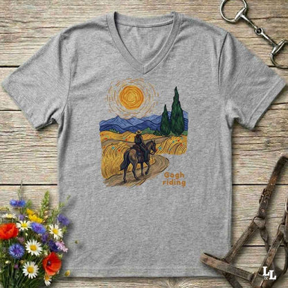 grey v-neck tee with van gogh inspired design and the words Gogh Riding, lying on barn style floorboards with flowers and horse halter and horse bit
