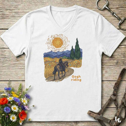 white v-neck tee with van gogh inspired design and the words Gogh Riding, lying on barn style floorboards with flowers and horse halter and horse bit