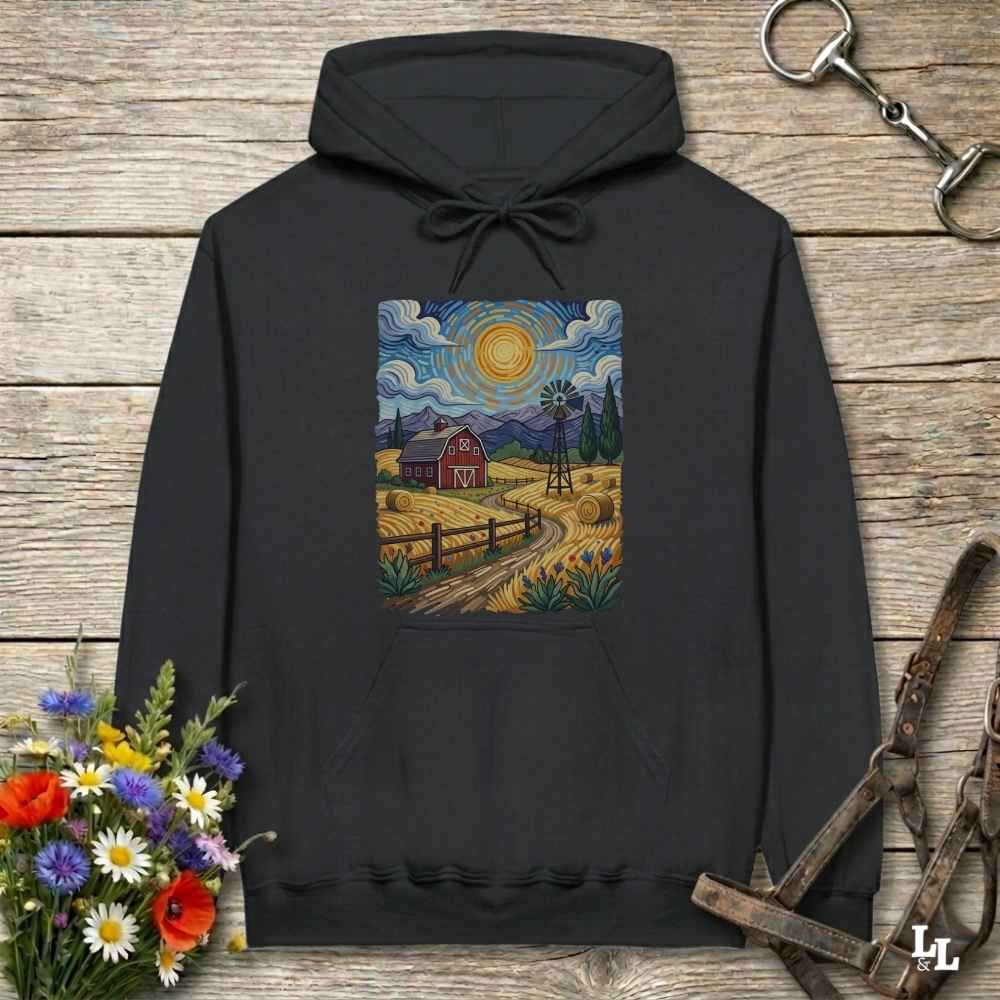 Black hoodie with a colorful farm scene design on a wooden surface with flowers and a bridle.