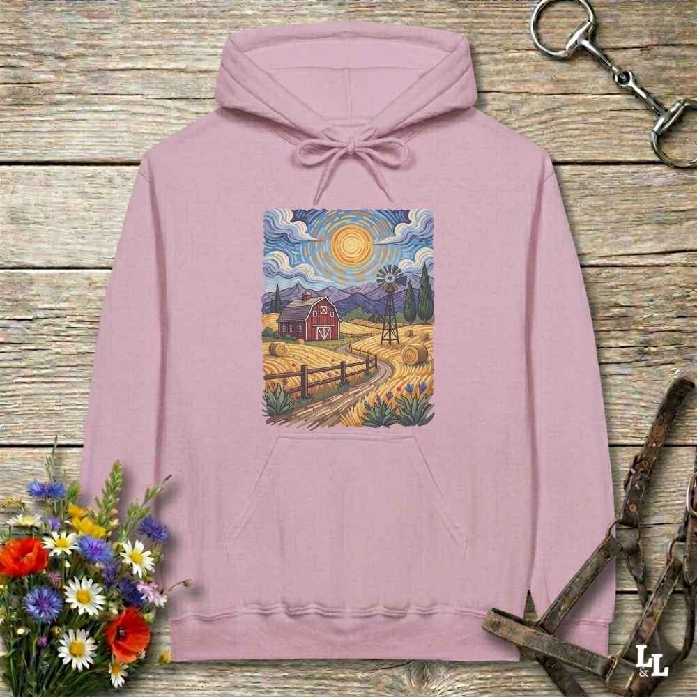 Pink hoodie with a farm scene print on a wooden surface with flowers and horse equipment. Gogh to the Barn.