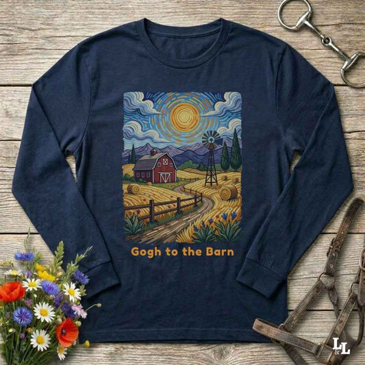 A navy blue long-sleeve t-shirt with a colorful 'Van Gogh style' barn farm graphic and the text 'Gogh to the Barn' printed on the front, displayed on a rustic wooden background with decorative flowers and tack.