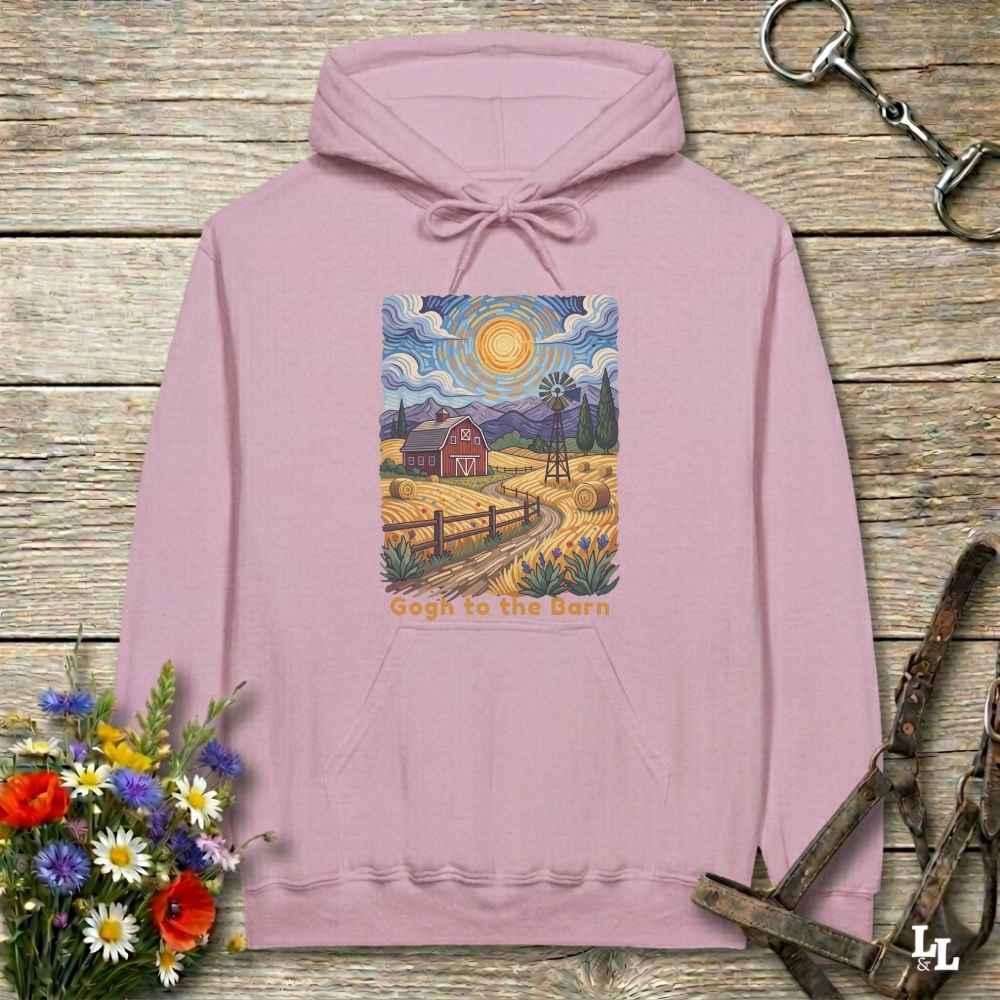 pink hoodie with a farm scene print on a wooden surface with flowers and horse equipment. Gogh to the Barn.