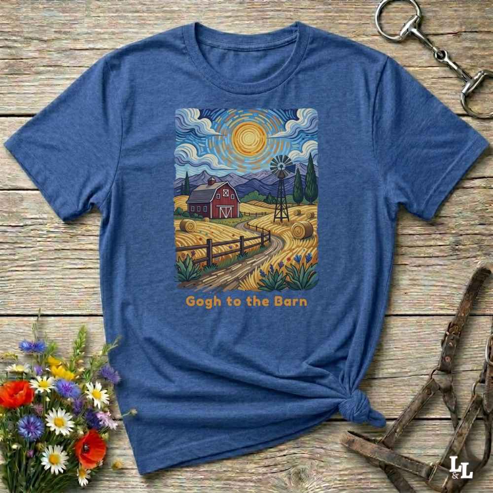 A flat lay mockup of a blue  t-shirt featuring Van Gogh-inspired landscape art of a farm, with a red barn, windmill, and hay bales under a swirling sun. Below the image, orange text reads, 'Gogh to the Barn.' Ideal horse lover and barn life gift.