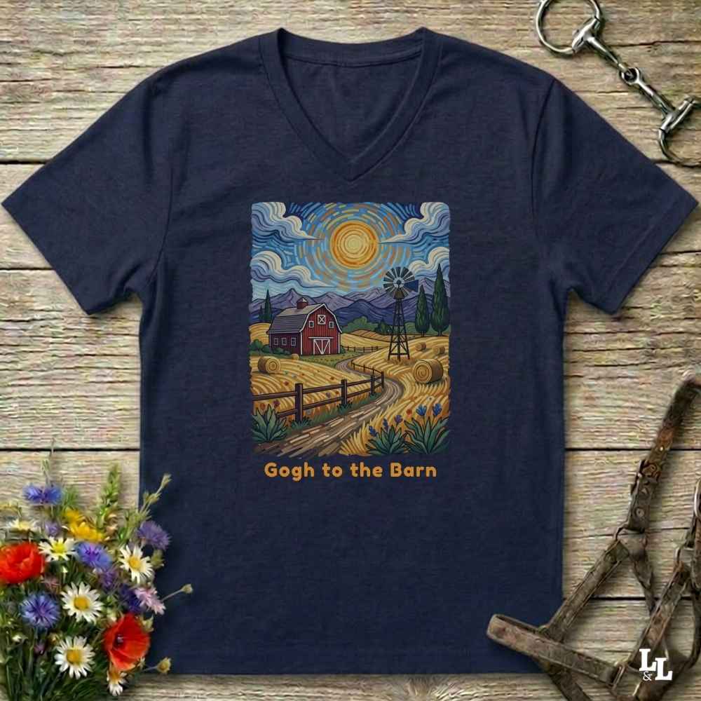 blue V-neck t-shirt laid flat on a rustic wooden surface, featuring a colorful Van Gogh-inspired barn scene graphic with the text 'Gogh to the Barn'. The shirt is styled with equestrian props (reins and a bit) and a small bouquet of wildflowers.