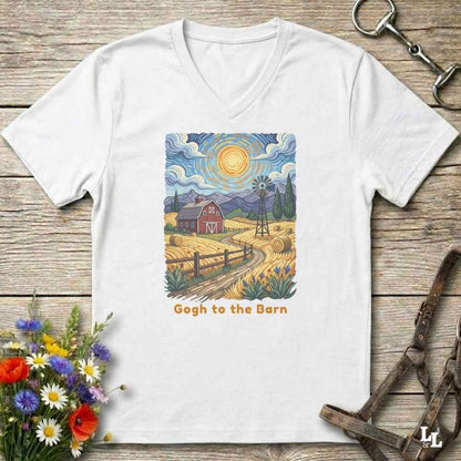 white V-neck t-shirt laid flat on a rustic wooden surface, featuring a colorful Van Gogh-inspired barn scene graphic with the text 'Gogh to the Barn'. The shirt is styled with equestrian props (reins and a bit) and a small bouquet of wildflowers.