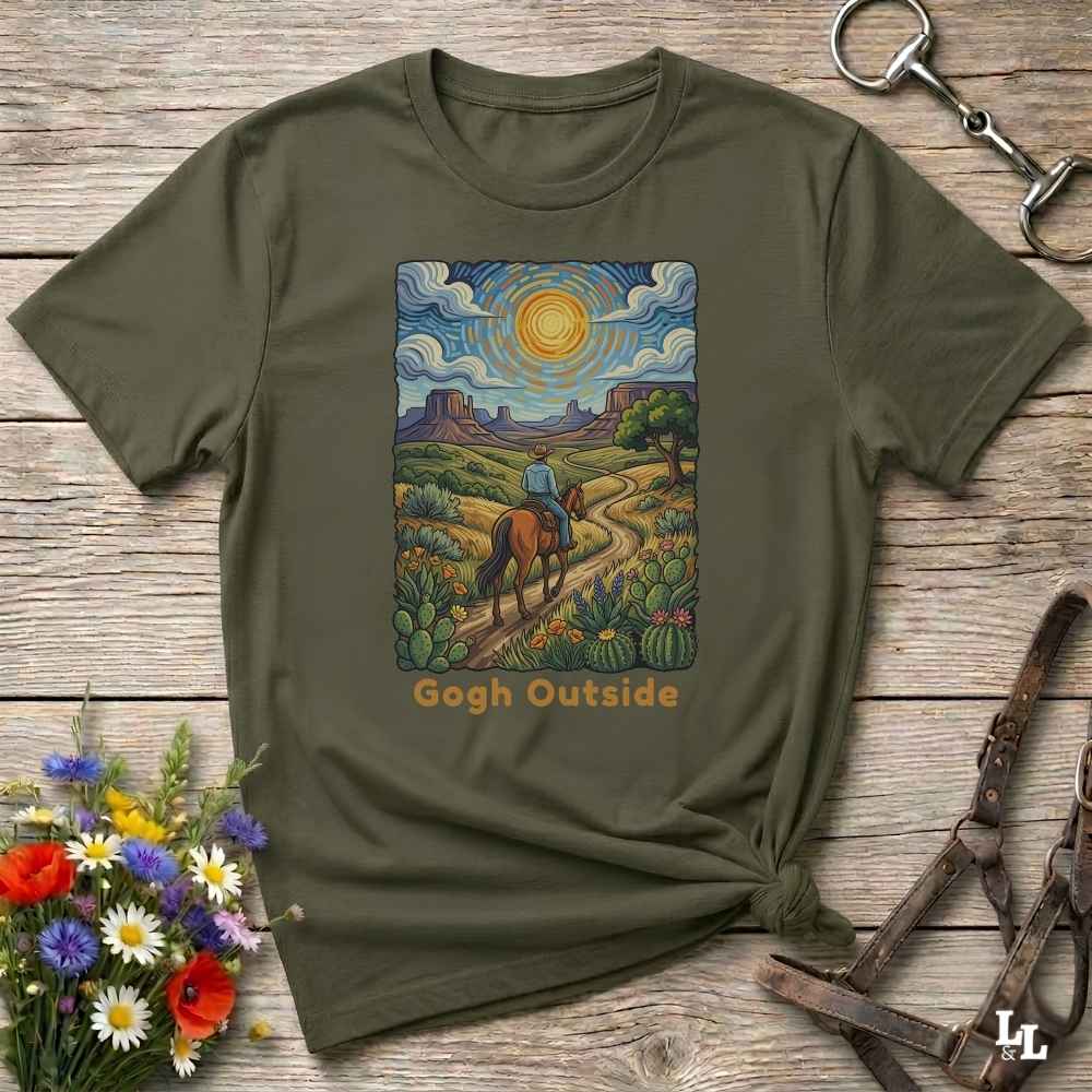 An olive green short-sleeve t-shirt with a colorful graphic print of a cowboy riding a horse through a desert landscape under a swirling blue sky. The text 'Gogh Outside' is printed below the graphic.