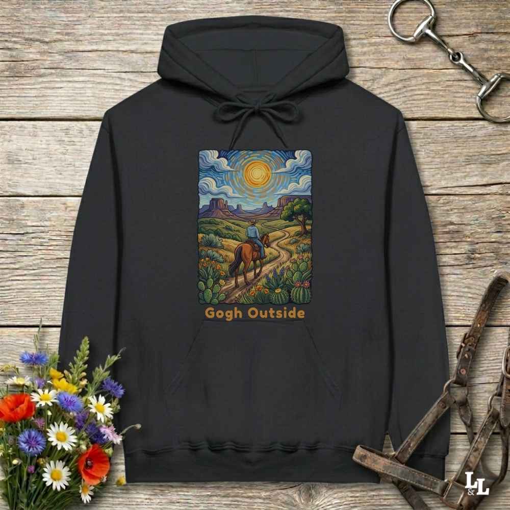 black Hoodie, Gogh Outside graphic design,  lying on wooden floor with equestrian halter and horse bit