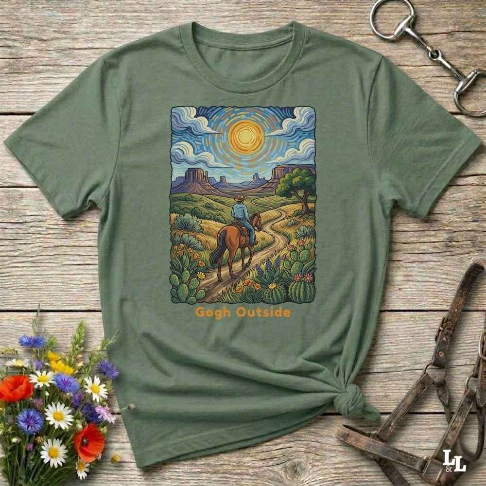 green t-shirt with a desert scene graphic and 'Gogh Outside' text on a wooden surface with flowers and a key. Perfect gift for horse lovers.