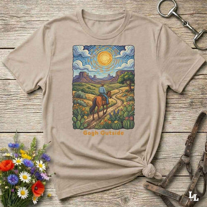 Beige t-shirt with a desert scene graphic and 'Gogh Outside' text on a wooden surface with flowers and a key. Perfect gift for horse lovers.