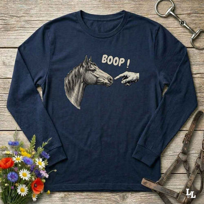 Navy blue long-sleeve shirt with horse graphic and 'BOOP!' text on a wooden surface with floral and equestrian accessories.