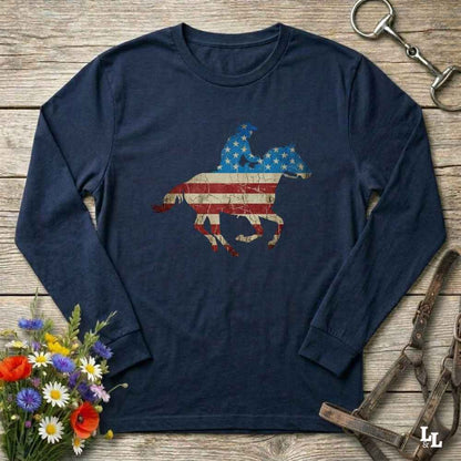 Navy blue long-sleeve shirt with American flag horse design on a wooden surface with floral and equestrian accessories.