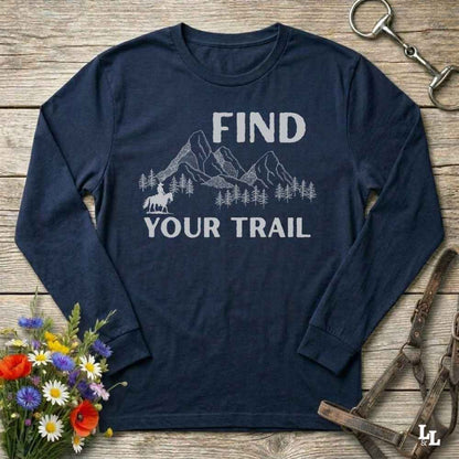 Navy blue long-sleeve shirt with 'Find Your Trail' graphic on a wooden surface with flowers and horse equipment.