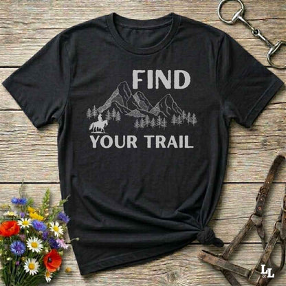 Black t-shirt with 'Find Your Trail' graphic on a wooden surface with floral and equestrian elements.