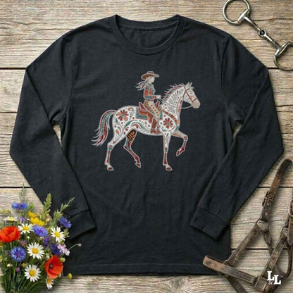 Black long-sleeve shirt with a colorful horse and rider design on a wooden surface with floral and equestrian-themed accessories.