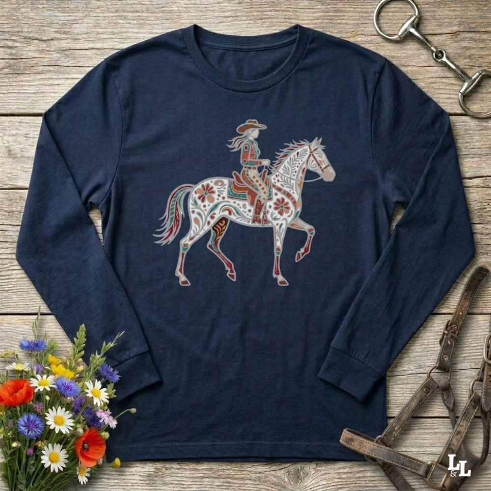 Navy blue long-sleeve shirt with a colorful horse and rider design on a wooden surface with floral and equestrian accessories.