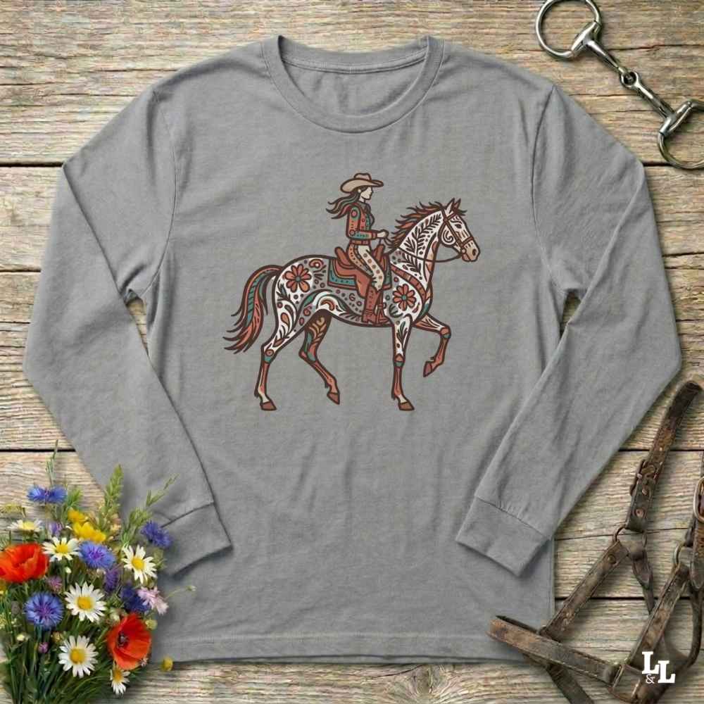 Gray long-sleeve shirt with a graphic of a woman riding a horse on a wooden surface with floral and equestrian-themed accessories.