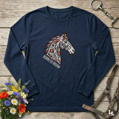 Navy blue long-sleeve shirt with a colorful horse design and 'Born to Roam' text on a wooden surface with floral and equestrian accessories.
