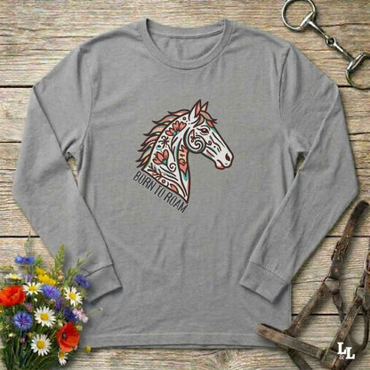 Gray long-sleeve shirt with a colorful horse graphic on a wooden surface with floral and equestrian-themed items.