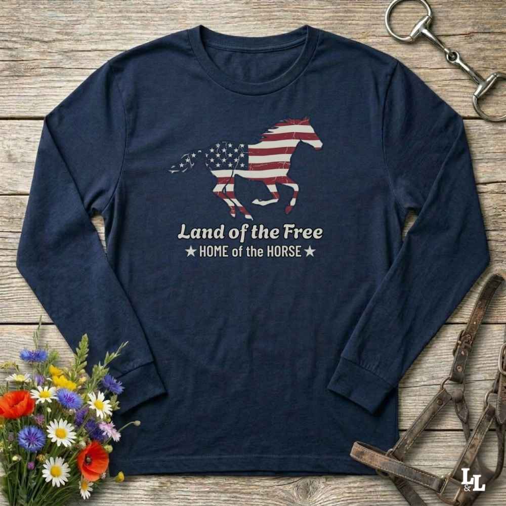 Navy blue long-sleeve shirt with American flag horse design on a wooden surface with floral and equestrian accessories.