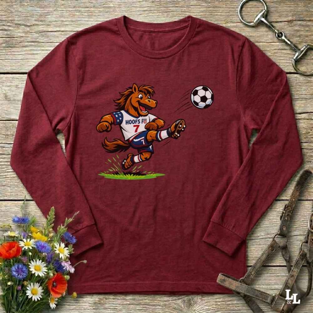 red  long-sleeve shirt with a cartoon horse kicking a soccer ball on a wooden surface with flowers and a horse bridle.