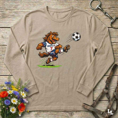 beige  long-sleeve shirt with a cartoon horse kicking a soccer ball on a wooden surface with flowers and a horse bridle.