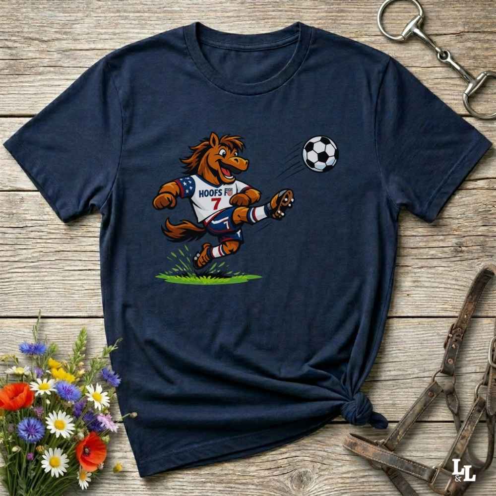 navy blue t-shirt with a cartoon horse kicking a soccer ball on a wooden surface with flowers and horse halter and bit.