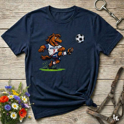 navy blue t-shirt with a cartoon horse kicking a soccer ball on a wooden surface with flowers and horse halter and bit.