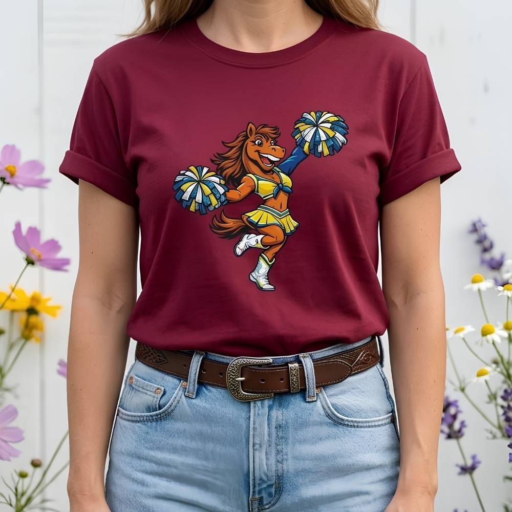 Person wearing a maroon t-shirt with a colorful graphic of a horse doing a cheerleading routine, standing against a white background with flowers.