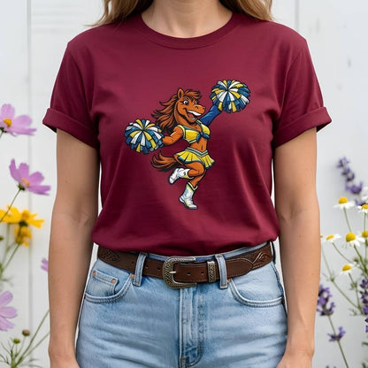 Person wearing a maroon t-shirt with a colorful graphic of a horse doing a cheerleading routine, standing against a white background with flowers.