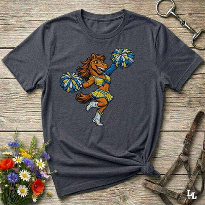 grey  t-shirt with a cartoon horse cheerleader design on a wooden surface with flowers and a horse bit