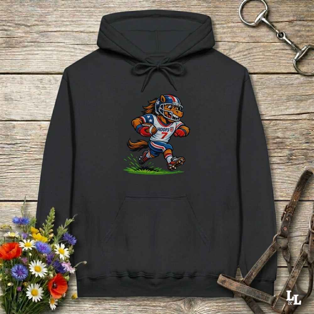 black hoodie with horse mascot playing american football, lying on wooden background with equestrian accessories