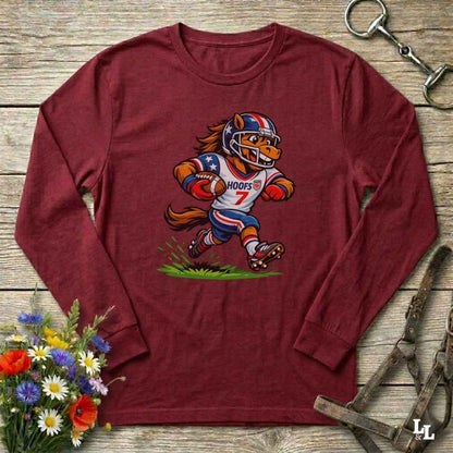 red  long-sleeve shirt with a cartoon horse in a american football uniform on a wooden surface with flowers and a horse halter and bit.