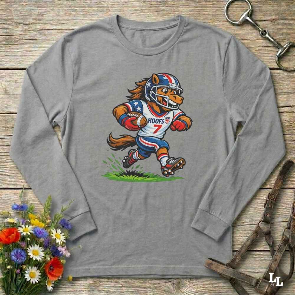 gray  long-sleeve shirt with a cartoon horse in a american football uniform on a wooden surface with flowers and a horse halter and bit.