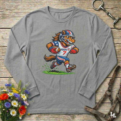 gray  long-sleeve shirt with a cartoon horse in a american football uniform on a wooden surface with flowers and a horse halter and bit.