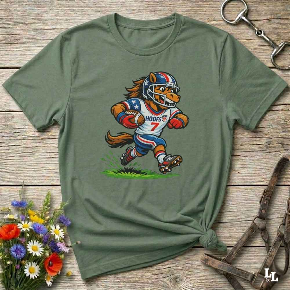 Green t-shirt with a cartoon football player design on a wooden surface with flowers and a bottle opener.