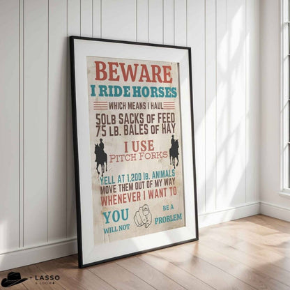 Framed poster with humorous text about riding horses in a room with wooden flooring and white walls.