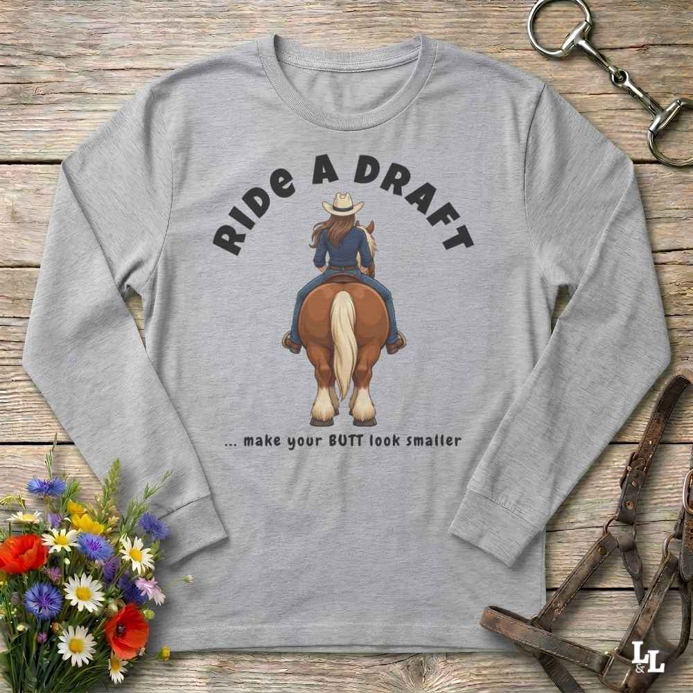 A light heather gray long-sleeve t-shirt with a graphic of a cowboy riding a brown horse, with the text 'RIDE A DRAFT .