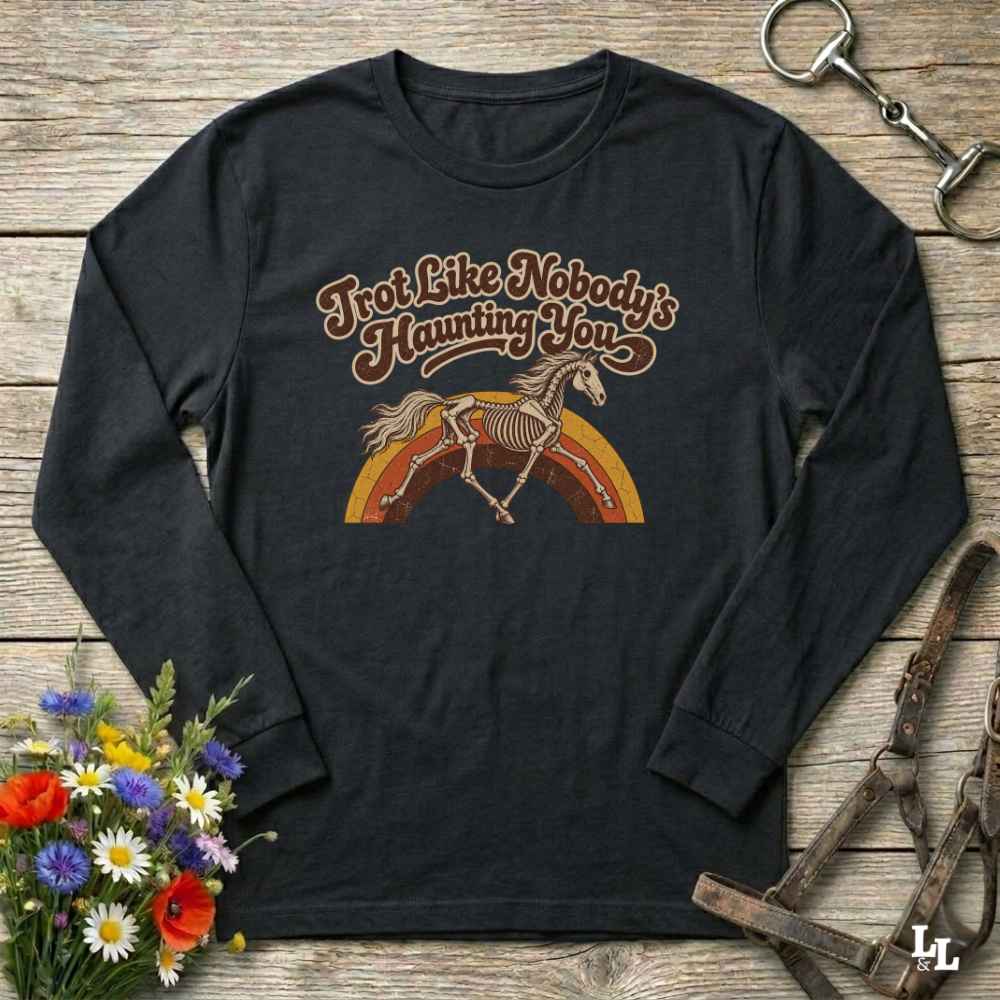 Navy blue long-sleeve shirt with 'I'm not retired, I ride horses' text on a wooden surface with floral and equestrian-themed items.