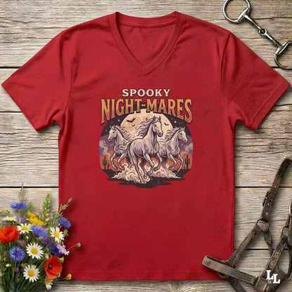 A red V-neck t-shirt with a 'Spooky Night-Mares' graphic print, laid flat on a rustic wooden background with horse tack and flowers as props.