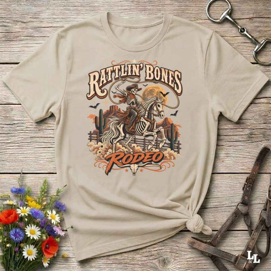 beige t-shirt with short sleeves, with halloween design of rattlin'bones rodeo, with skull cowboy riding a horse in the desert