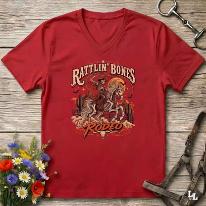 A red  Halloween V-neck t-shirt with a detailed western skeleton cowboy graphic on the chest, styled in a flat-lay on a rustic wooden background with equestrian and floral props.