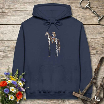 A navy blue pullover hoodie with a graphic of a cowboy riding a horse, displayed on a rustic wooden background with equestrian-themed props like a halter, reins, and a small bouquet of wildflowers.