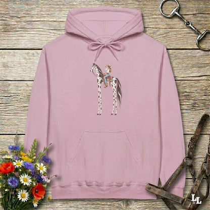 A pink pullover hoodie with a graphic of a cowboy riding a horse, displayed on a rustic wooden background with equestrian-themed props like a halter, reins, and a small bouquet of wildflowers.