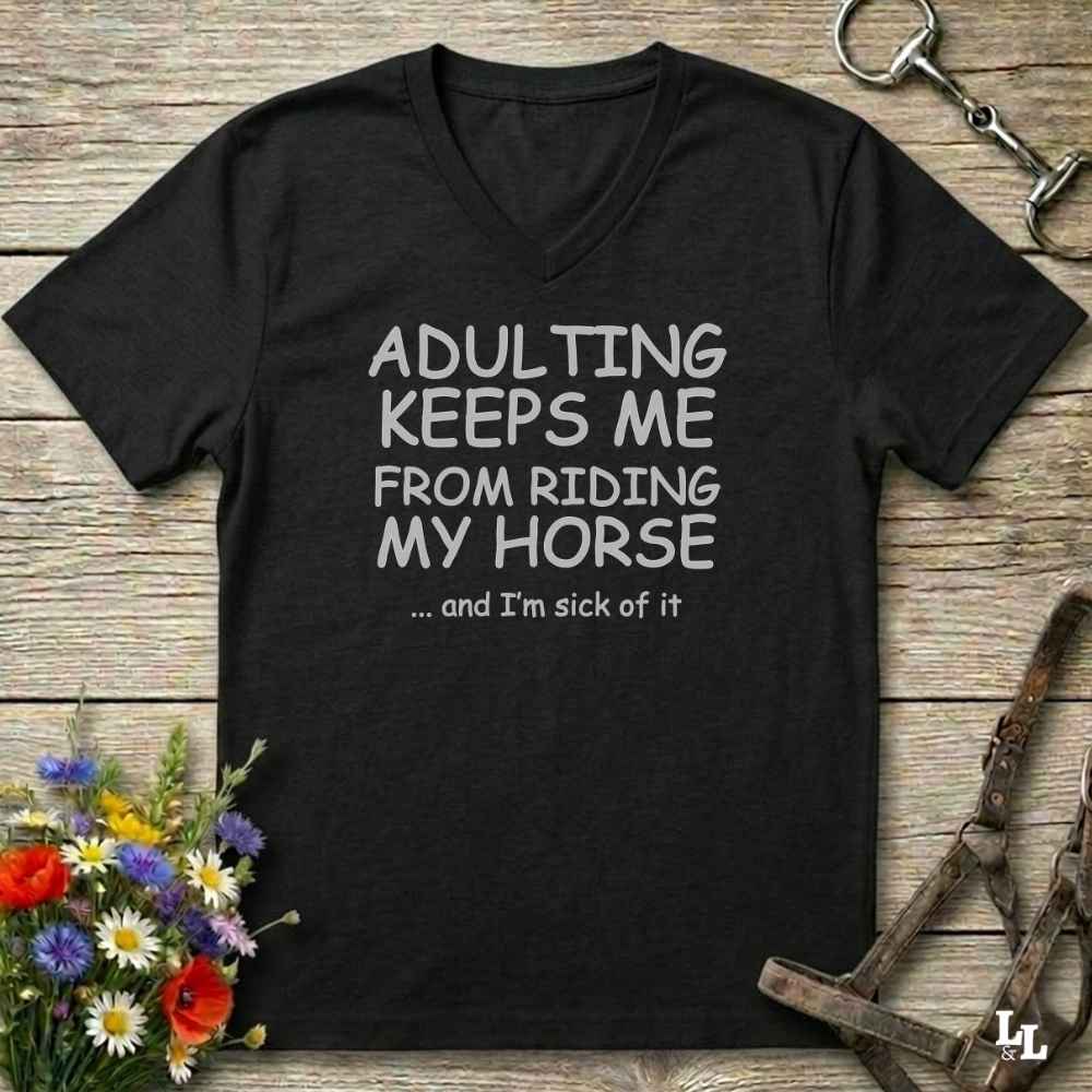 A black V-neck t-shirt with white text reading 'ADULTING KEEPS ME FROM RIDING MY HORSE .