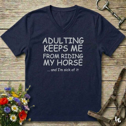 A navy blue V-neck t-shirt with white text reading 'ADULTING KEEPS ME FROM RIDING MY HORSE .